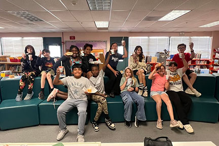 Students pose on the couch in the library with their slushie drinks